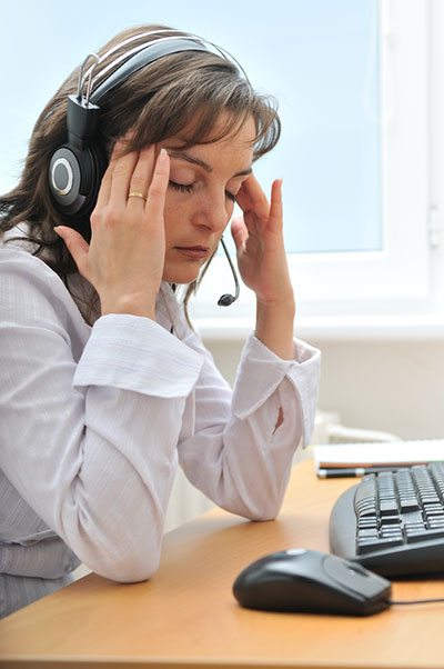 A stressed woman wearing a headset