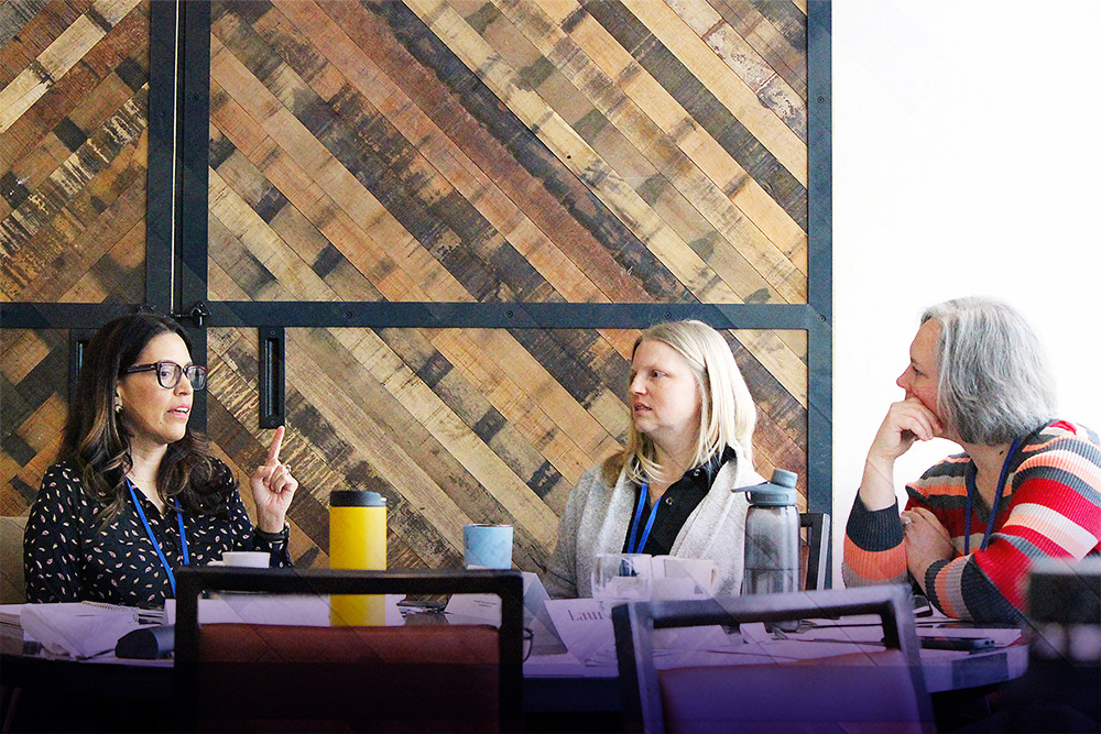 Photograph of scholars talking at a table duing the Leadership Institute