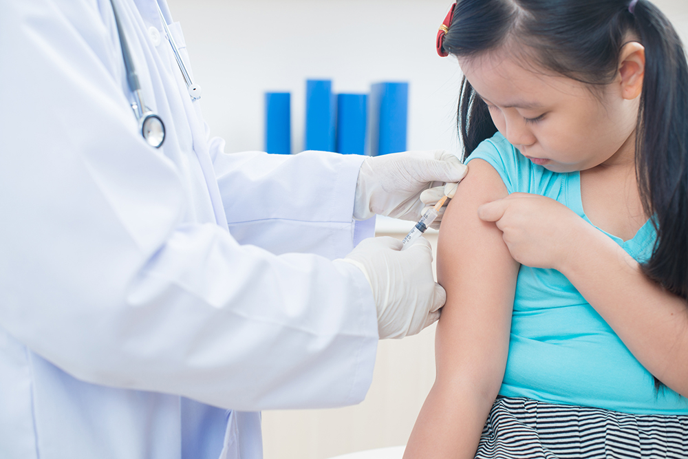 Photograph of a young girl receiving an immunization.