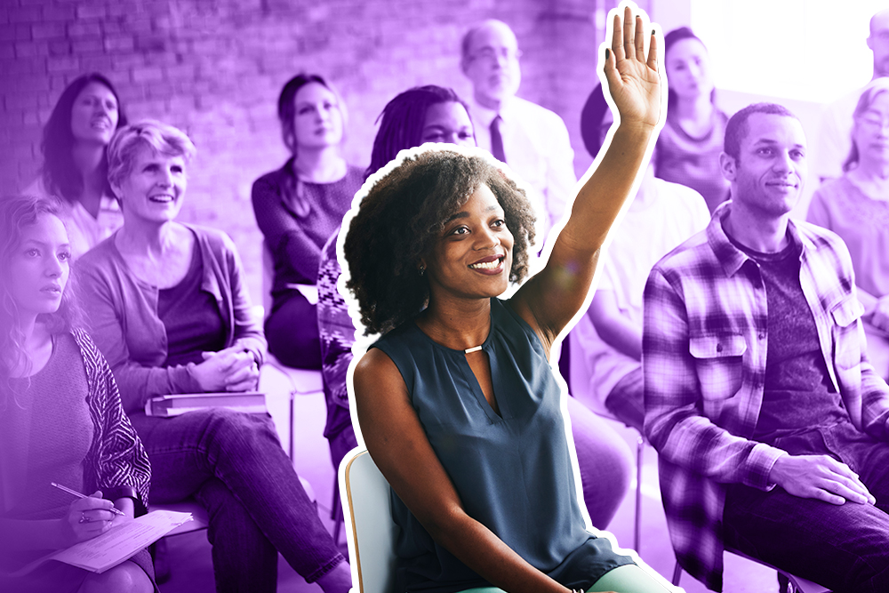 Photo of woman in a classroom raising her had with a purple background