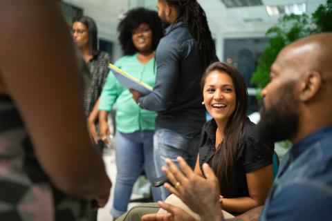 Photograph of a group of people smiling and talking.