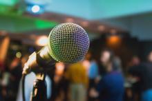 Open microphone with audience standing in the backgorund