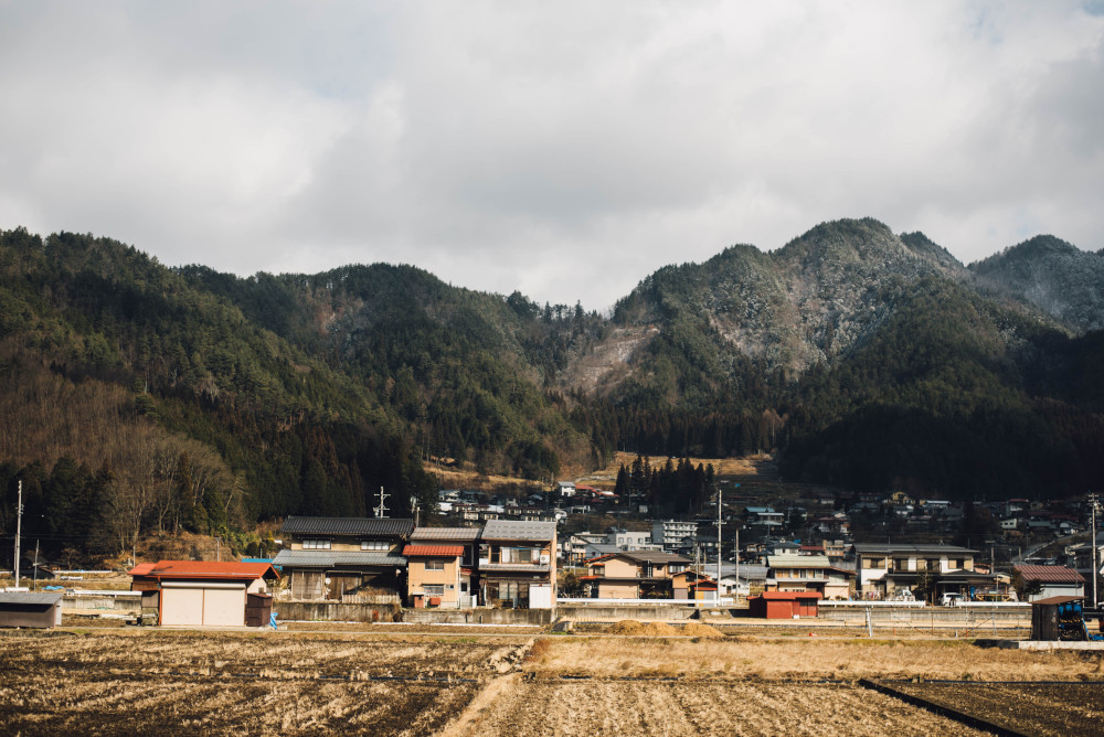 Photograph of rural town near hills.