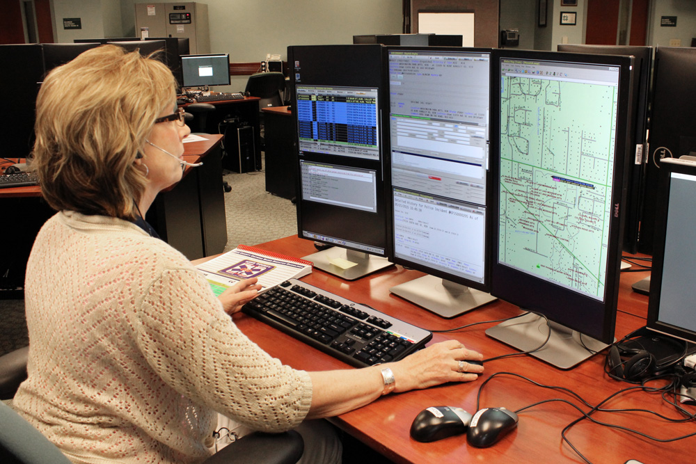 A 9-1-1 telecommunicator at her workstation.