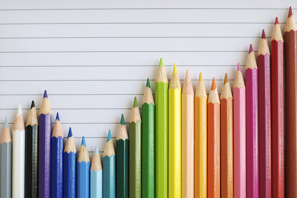 Photograph of a chart formed from a rainbow of colored pencils.