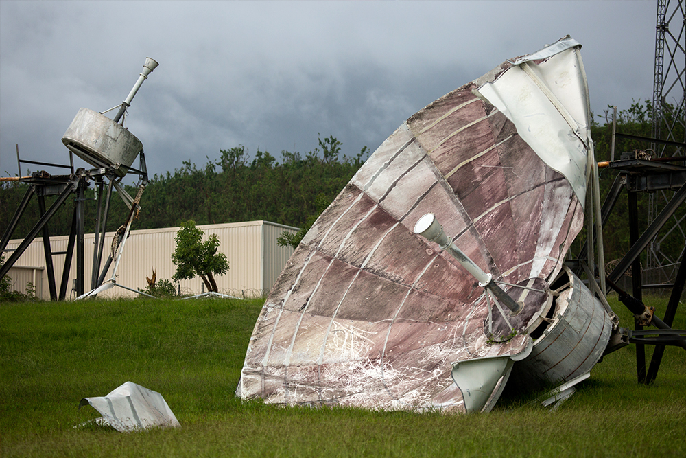 Photograph of satellite dish that has been destroyed by a storm.