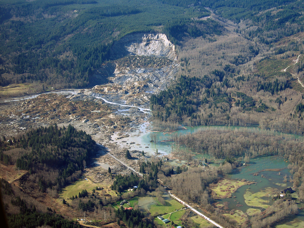 Photograph of Oso slide showing a large area of hillside has slid into the river valley.