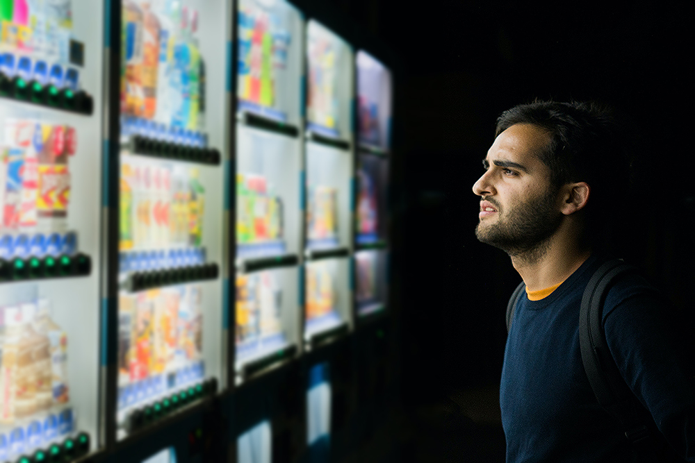 man-staring-at-vending-machines