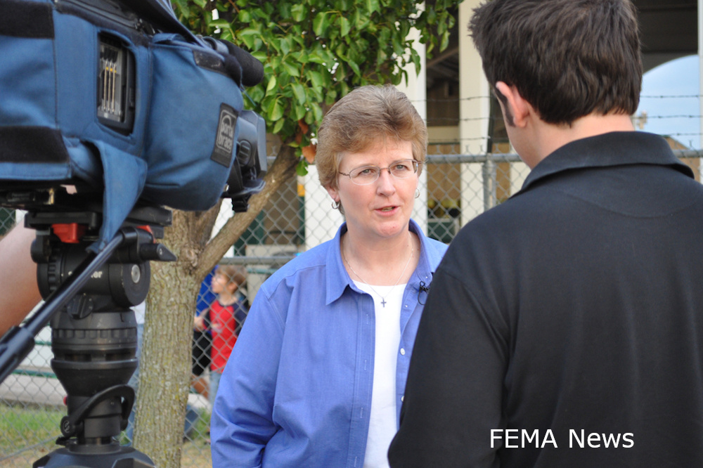 Photograph of a public information officer addressing the media.