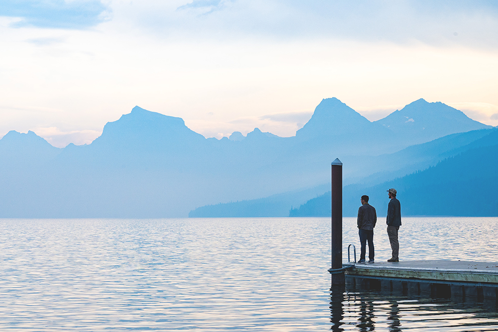 Photograph of two people on the end of a dock seen from a distance.