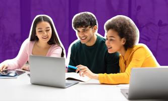 Photograph of three students looking at a laptop computer.