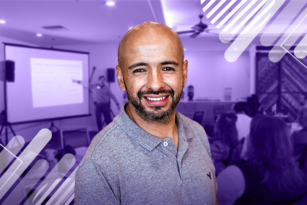 Photograph of Memo with blurred image of onsite room behind him and purple graphic lines