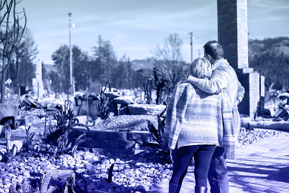 A couple looking at a destroyed home.